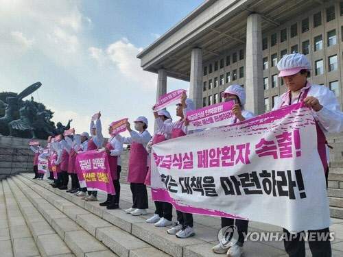 전국학교비정규직노동조합 급식실 조합원들이 지난해 11월 8일 서울 영등포구 국회 본관 계단에서 학교급식실 폐암 산재 대책 마련과 노동환경 개선 예산 편성을 요구하며 기자회견을 하고 있다. [전국학교비정규직노동조합 제공= 연합뉴스]